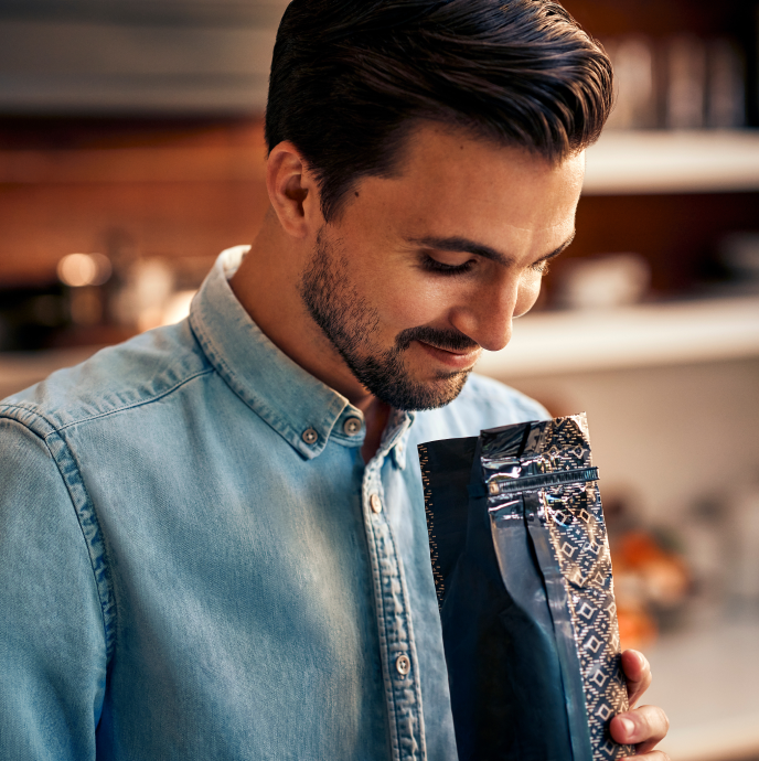 Person enjoying a delivery of freshly roasted coffee